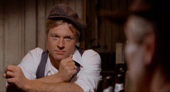 Movie still from “The Sting” (1973), directed by George Roy Hill – A man wearing a brown hat and a white shirt; Close Up shot, Over the shoulder angle