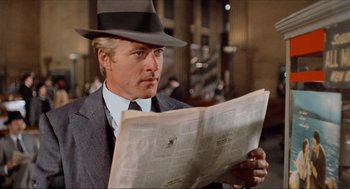 Movie still from “The Sting” (1973), directed by George Roy Hill – A man in a suit and hat reading a newspaper; Close Up shot, Over the shoulder angle