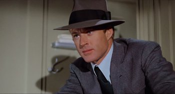 Movie still from “The Sting” (1973), directed by George Roy Hill – A person wearing a suit and a hat; Close Up shot, Low angle
