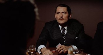 Movie still from “The Sting” (1973), directed by George Roy Hill – A man sitting at a table with a card in his hand; Close Up shot, Over the shoulder angle