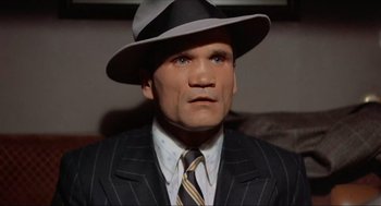 Movie still from “The Sting” (1973), directed by George Roy Hill – A person wearing a suit and a hat; Close Up shot, High angle