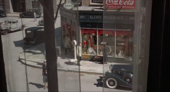Movie still from “The Sting” (1973), directed by George Roy Hill – An old photo of a street scene with a vintage car; Extreme Wide shot, High angle