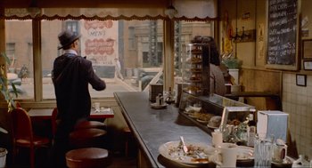 Movie still from “The Sting” (1973), directed by George Roy Hill – A man standing at a counter in a restaurant; Wide shot, Over the shoulder angle