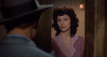 Movie still from “The Sting” (1973), directed by George Roy Hill – A woman standing in front of a man in front of a mirror; Close Up shot, Over the shoulder angle