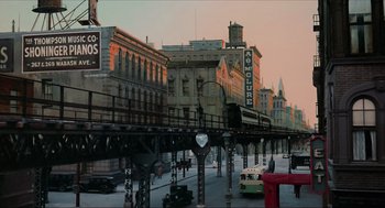 An image of a city street with a train station in the background