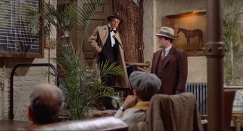 Movie still from “The Sting” (1973), directed by George Roy Hill – A group of men standing next to each other in a room; Wide shot, Over the shoulder angle