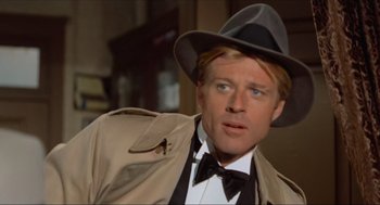 Movie still from “The Sting” (1973), directed by George Roy Hill – A person wearing a suit and hat; Close Up shot, Low angle
