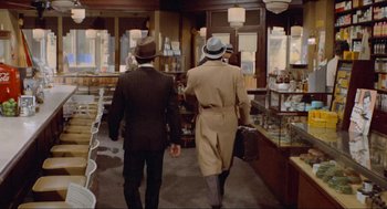 Movie still from “The Sting” (1973), directed by George Roy Hill – Two men in suits and hats walking in a store; Wide shot, High angle