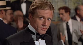 Movie still from “The Sting” (1973), directed by George Roy Hill – A person wearing a suit and bow tie; Close Up shot, Low angle