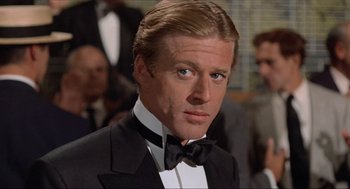 Movie still from “The Sting” (1973), directed by George Roy Hill – A person wearing a suit and bow tie; Close Up shot, Over the shoulder angle