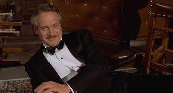 Movie still from “The Sting” (1973), directed by George Roy Hill – A man in a tuxedo sitting in a chair; Medium shot, Low angle