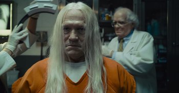 Movie still from “The Suicide Squad” (2021), directed by James Gunn – An old man with long white hair is in an orange prison uniform; Close Up shot, Over the shoulder angle