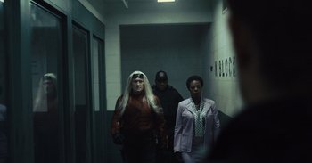 Movie still from “The Suicide Squad” (2021), directed by James Gunn – A group of people walking down a hall way; Medium shot, Over the shoulder angle