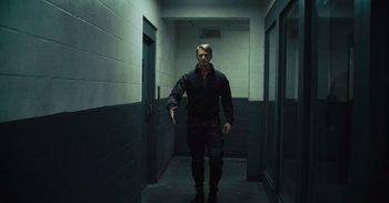 Movie still from “The Suicide Squad” (2021), directed by James Gunn – A man walking down a hallway in a building; Wide shot, Low angle