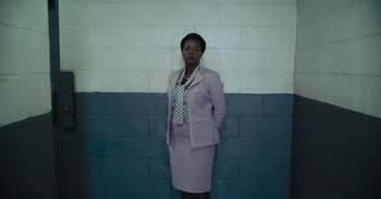 Movie still from “The Suicide Squad” (2021), directed by James Gunn – A woman standing in front of a brick wall; Medium shot, Low angle