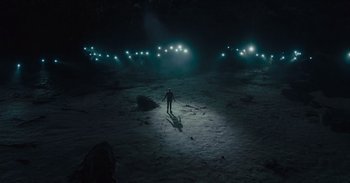 Movie still from “The Suicide Squad” (2021), directed by James Gunn – A man standing in the middle of a field at night; Extreme Wide shot, High angle