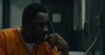 Movie still from “The Suicide Squad” (2021), directed by James Gunn – A man in an orange shirt is talking on the phone; Close Up shot, Over the shoulder angle