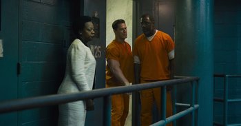 Movie still from “The Suicide Squad” (2021), directed by James Gunn – A group of men and a woman standing next to a railing; Wide shot, Low angle
