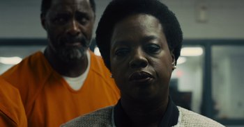 Movie still from “The Suicide Squad” (2021), directed by James Gunn – An older man and a younger woman in an orange prison uniform; Close Up shot, Over the shoulder angle