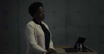 Movie still from “The Suicide Squad” (2021), directed by James Gunn – A woman sitting in front of a laptop computer; Medium shot, Over the shoulder angle