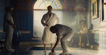 Movie still from “The Suicide Squad” (2021), directed by James Gunn – Two men in white robes are standing in front of a stained glass window; Wide shot, Low angle