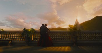 Movie still from “The Suicide Squad” (2021), directed by James Gunn – Two people standing on a balcony at sunset; Extreme Wide shot, Low angle