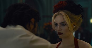 Movie still from “The Suicide Squad” (2021), directed by James Gunn – A woman with a red flower in her hair looking into a mirror; Close Up shot, Over the shoulder angle