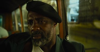 Movie still from “The Suicide Squad” (2021), directed by James Gunn – A person with a beard wearing a hat; Close Up shot, Low angle