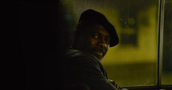 Movie still from “The Suicide Squad” (2021), directed by James Gunn – A man with a black hat is smiling for the camera; Close Up shot, High angle