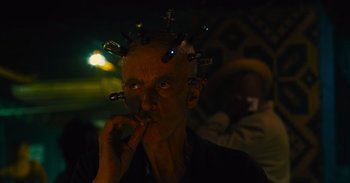 Movie still from “The Suicide Squad” (2021), directed by James Gunn – A man with a lot of hair on his head; Close Up shot, Low angle