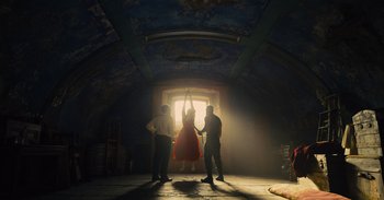 Movie still from “The Suicide Squad” (2021), directed by James Gunn – Three people standing in a dimly - lit room; Extreme Wide shot, Low angle
