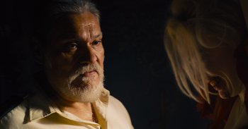 Movie still from “The Suicide Squad” (2021), directed by James Gunn – An old man with a beard is talking to a woman; Close Up shot, Over the shoulder angle