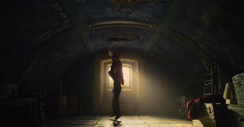 Movie still from “The Suicide Squad” (2021), directed by James Gunn – A person standing in a room with a light shining in the window; Wide shot, Low angle