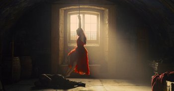 Movie still from “The Suicide Squad” (2021), directed by James Gunn – A woman in a red dress hanging from a rope; Wide shot, Low angle