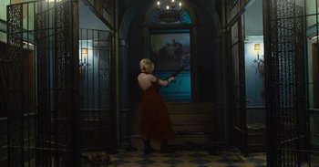 Movie still from “The Suicide Squad” (2021), directed by James Gunn – A woman in a red dress is holding a sword; Wide shot, High angle