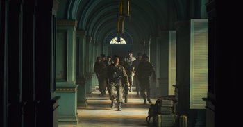 Movie still from “The Suicide Squad” (2021), directed by James Gunn – A group of soldiers walking down a hall way; Wide shot, Low angle