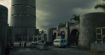Movie still from “The Suicide Squad” (2021), directed by James Gunn – A bus parked in front of an old building; Extreme Wide shot, Low angle