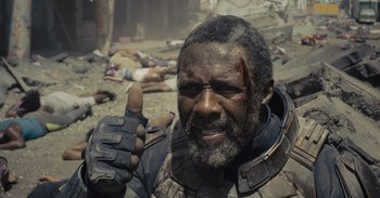 Movie still from “The Suicide Squad” (2021), directed by James Gunn – A man with a beard and a helmet is giving a thumbs up; Close Up shot, Low angle