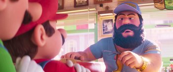 Movie still from “The Super Mario Bros. Movie” (2023), directed by Aaron Horvath – A man in a blue shirt and a man in a blue hat; Close Up shot, Over the shoulder angle