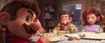 Movie still from “The Super Mario Bros. Movie” (2023), directed by Aaron Horvath – A group of people sitting around a table eating food; Close Up shot, Over the shoulder angle