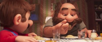 Movie still from “The Super Mario Bros. Movie” (2023), directed by Aaron Horvath – A man with a beard is eating pasta at a table; Close Up shot, Overhead angle