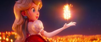 Movie still from “The Super Mario Bros. Movie” (2023), directed by Aaron Horvath – A woman in a red and white dress holds out her hand to a flame; Medium shot, Over the shoulder angle