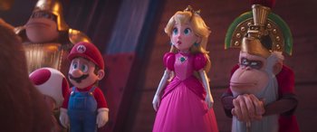 Movie still from “The Super Mario Bros. Movie” (2023), directed by Aaron Horvath – A girl in a pink dress is standing next to a boy in a red suit; Medium shot, Over the shoulder angle