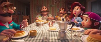 Movie still from “The Super Mario Bros. Movie” (2023), directed by Aaron Horvath – A table set up for a meal with two men sitting at the table; Medium shot, Over the shoulder angle