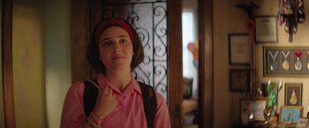 Movie still from “The Swimmers” (2022), directed by Sally El Hosaini – A woman in a pink shirt holding a cell phone; Close Up shot, Over the shoulder angle