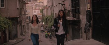 Movie still from “The Swimmers” (2022), directed by Sally El Hosaini – Two women walking down a street in a city; Wide shot, Low angle
