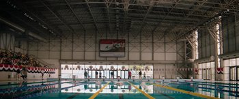 Movie still from “The Swimmers” (2022), directed by Sally El Hosaini – A swimming pool that has a lot of people in it; Extreme Wide shot, High angle