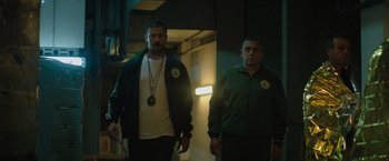 Movie still from “The Swimmers” (2022), directed by Sally El Hosaini – A man and a man standing next to each other in a room; Medium shot, Low angle