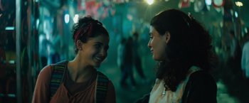 Movie still from “The Swimmers” (2022), directed by Sally El Hosaini – Two young women are talking and laughing together; Close Up shot, Low angle