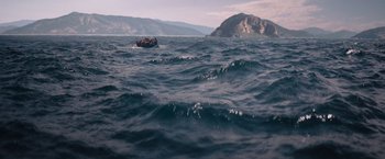 Movie still from “The Swimmers” (2022), directed by Sally El Hosaini – A boat floating on top of a large body of water; Extreme Wide shot, High angle
